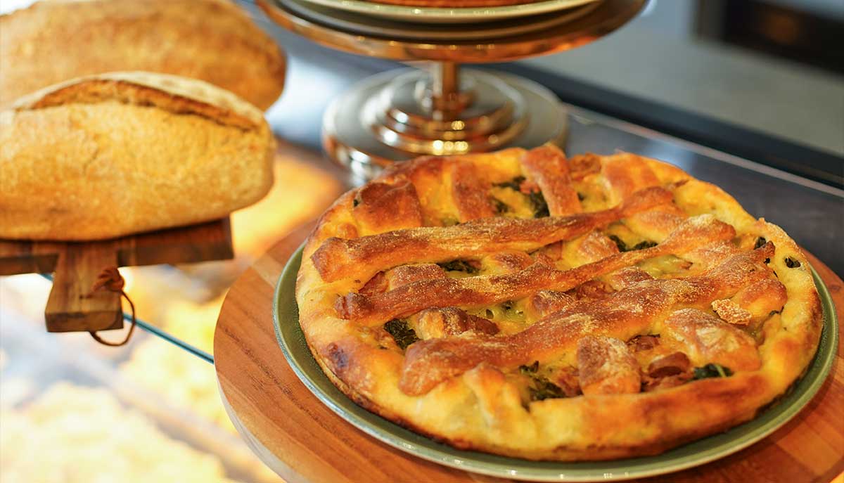 Pizza condita e pane su un tagliere