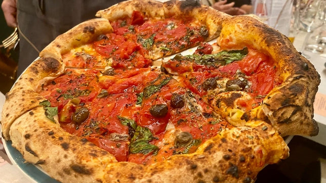 Pizza di Modus appena sfornata con pomodoro e basilico