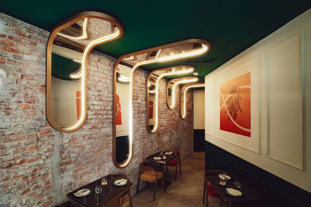 Sala della pizzeria Modus con pareti in mattoni, luci a tubo e tavoli